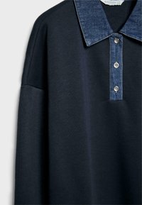 Chemise bleu marine à manches longues avec un col en denim et une patte de boutonnage à trois boutons.