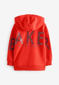 Sarkans kapucis džemperis ar lielām pelēkām "BAKER" burtiem aizmugurē, zem kuriem mazākiem burtiem rakstīts "by TED BAKER". Mīksta auduma.