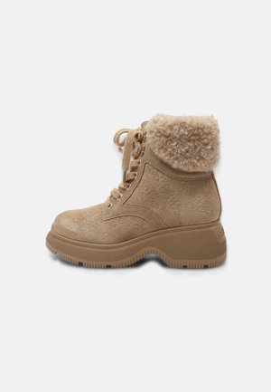Bottine beige en daim à lacets avec semelle épaisse et revers replié doublé de fausse fourrure beige douce.