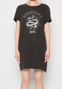 Czarna bawełniana sukienka t-shirtowa z krótkimi rękawami, zaokrąglonym dekoltem i grafikiem przedstawiającym węża oraz tekst, o luźnym kroju.
