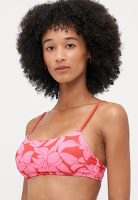 Roze bloemen bikini top met verstelbare rode banden; beschikt over een soepele, rekbare stof en een levendig bloemenpatroon.