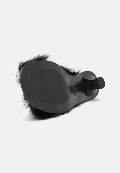 Saboturi negre cu vârf deschis, având un material pufos pe partea superioară și o talpă plată, netedă. Prezintă un toc masiv și un design minimalist, fără branding vizibil.