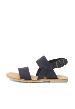 Sandalias de ante azul marino con dos cintas anchas y una correa ajustable en el tobillo, sobre una suela de color marrón claro. Diseño de punta abierta y suela plana para mayor comodidad.