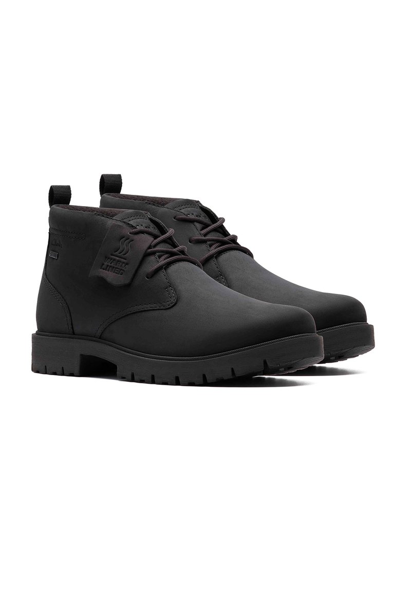 Schwarze Knöchelstiefel mit glatter Oberfläche, runder Spitze und robuster Sohle. Das Schnürdesign verfügt über Zuglaschen und ein Branding-Detail zur Wärmerückhaltung.