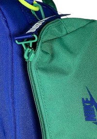 Borsa a spalla Nike blu e verde con tessuto texturizzato, chiusura con zip e marchio. Presenta una zip verde e un anello di attacco giallo.