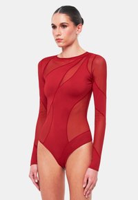 Röd bodysuit med långa genomskinliga meshärmar och en strukturerad, enfärgad kropp. Har böjda sömmar och rundad halsringning. Figurformad design.