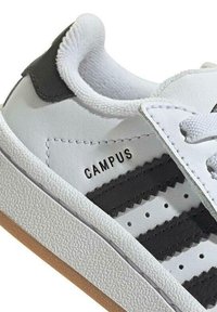 Weiße Leder-Sneaker mit schwarzen Streifen, runder Spitze, strukturierten Gummisohle und gepolstertem Kragen. Mit "CAMPUS"-Aufdruck an der Seite.