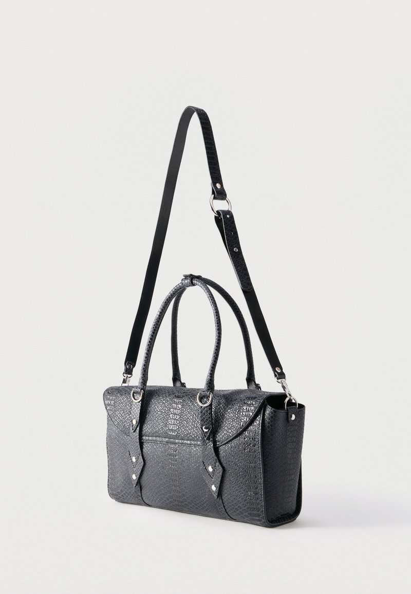 Borsa a mano in pelle nera testurizzata con manici superiori e tracolla lunga regolabile su sfondo chiaro semplice.