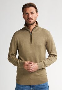 Beige Zip-Hals Pullover mit langen Ärmeln, gerippten Bündchen und Saum, aus glattem Stoff gefertigt. Verfügt über einen leicht schimmernden Effekt und minimale Nähdetails.