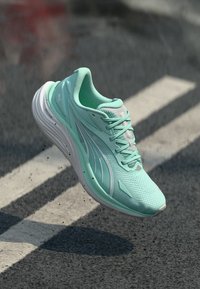 Chaussure de course légère en maille vert menthe, présentant une tige texturée, des accents réfléchissants et une semelle rembourrée pour un soutien optimal.