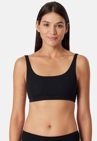 Svart ribbad bralette med breda remmar och djup ringning, med en sömlös band nederst och en jämn yta.