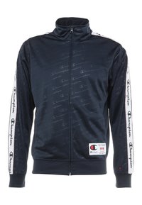 Marinblå zip-up träningsjacka med subtilt logomönster, hög krage, elastiska ärmmuddar och Champion-logotyp på vita sidosträck. Har en frontdragkedja.