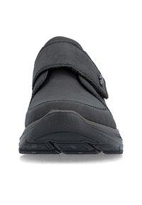 Chaussure orthopédique noire avec un avant large, une semelle texturée et une bride Velcro réglable sur le dessus, vue de face.