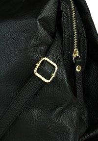 Zwarte leren handtas met een gestructureerd oppervlak, gouden hardware accenten, een ritssluiting en een vierkante gespdetail op de schouderband.