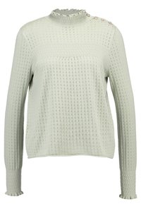 Pull en maille vert clair avec un col froncé haut, un design texturé, des manches longues et des boutons décoratifs à l'épaule.