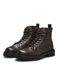 Bruine leren wandelschoenen met een gestructureerde afwerking, vetersluiting, metalen lietjes, nepleren voering en robuuste zwarte rubberen zolen.