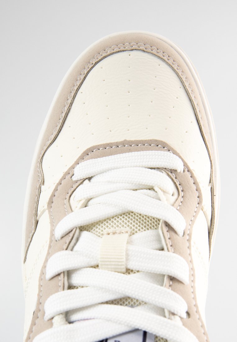Sneaker chiaro con tomaia in pelle liscia, dettagli in rete, accenti crema e beige, punta rotonda e spesse stringhe bianche.