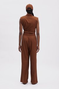 Completo senza maniche marrone con vita cintata e pantaloni dal taglio ampio, realizzato in un tessuto liscio. Include un cappello abbinato marrone.