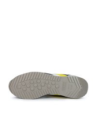 Suela de zapatilla de goma gris claro, con patrones de banda de rodadura circulares y estrías, y un pequeño detalle de logo que dice "Munich desde 1939."