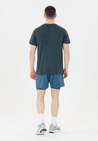 Herrarnas sportutfit: mörkgrå t-shirt, blå shorts, vita strumpor och grå löparskor med reflektiva detaljer och texturerade sulor.