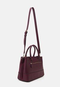 Burgundy handbag with a structured design, synthetic material, dual top handles, detachable shoulder strap, and a front zip pocket.