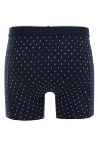Marinblå boxershorts i mjukt material, med ett upprepande vitt litet triangulärt mönster och en kontrasterande elastisk midja.