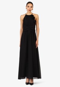 Schwarzes Maxikleid mit Halterneck, gerafftem Oberteil und verdrehtem Stoffdetail. Mit blumigen Akzenten an der Schulter und einem fließenden Rock.
