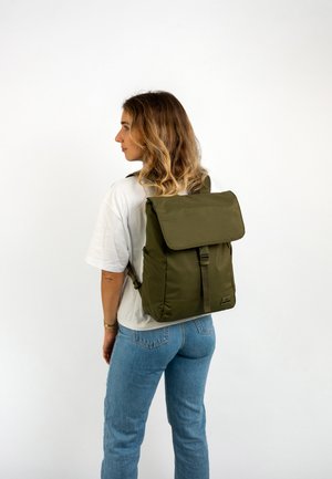 Olive green backpack with a flap closure, made from durable fabric, featuring adjustable straps and a sleek rectangular design.