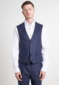 Marinefarbener Wollweste im Slim-Fit, mit V-Ausschnitt, Fünf-Knopf-Verschluss und zwei vorderen Taschen, kombiniert mit einem weißen Langarmhemd.