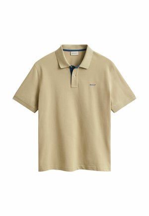 Polo beige a maniche corte con abbottonatura a due bottoni, piccolo logo blu sul petto a sinistra e fodera interna del colletto a contrasto.