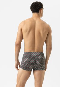 Zwemshorts van een donkere stof, met een kleurrijk bloemenpatroon. Hoog gesneden boven de dij, met een zachte textuur voor comfort.