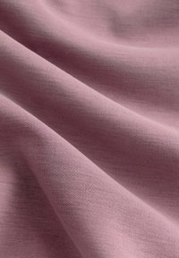 Pehmeä, kevyt kangas hennossa vaaleanpunaisessa sävyssä, jossa on tasainen pinta ja hienovarainen venyvyys, sopii erilaisiin vaatteisiin.