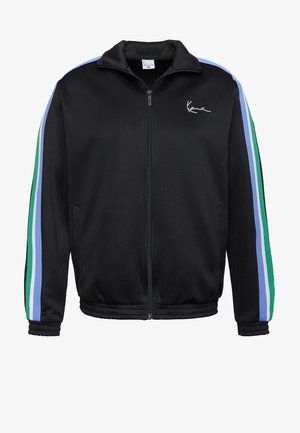 Fekete cipzáras dzseki állógallérral, zöld, kék és világoskék csíkozással az ujjakon. Sima tapintású, rugalmas mandzsettákkal.