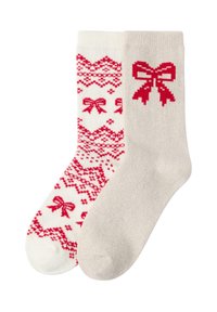 Skarpetki w czerwono-białe wzory; jedna skarpetka ma kokardki i geometryczny wzór, podczas gdy druga jest jednolita beżowa z grafiką czerwonej kokardki.