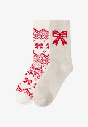 Rote und weiße gemusterte Socken; eine Socke zeigt Schleifen und ein geometrisches Design, während die andere einheitlich beige mit einer roten Schleifen-Grafik ist.