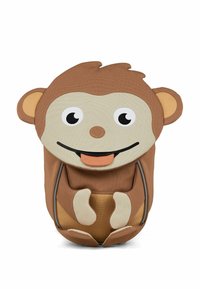 Mochila de tela en forma de mono marrón. Presenta grandes ojos, orejas redondas y una boca abierta con una lengua. Incluye patas definidas y acentos.
