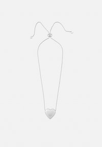 Ezüst nyaklánc szív alakú medállal, sima felületű és állítható lánccal, minimalista dizájnal és diszkrét márkajelzéssel.