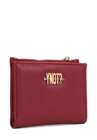 Portafoglio in ecopelle rossa con logo "YNOT?" in tonalità oro, chiusura a zip, superficie strutturata e forma rettangolare compatta.