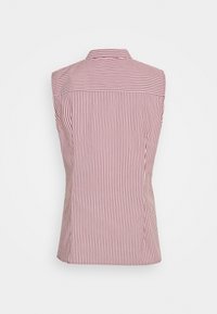 Blouse sans manches à rayures rouges et blanches avec col montant, de forme ajustée et à texture lisse. L'arrière présente un design épuré sans embellissements.