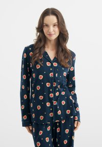 Granatowy zestaw piżamowy wykonany z miękkiego materiału, z wzorem czerwonych truskawek i żółtych gwiazdek. Zawiera bluzkę zapinaną na guziki oraz pasujące spodnie.