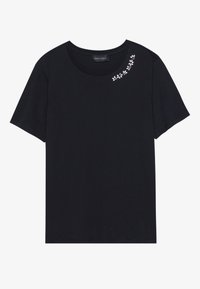 T-shirt noir en coton, avec un col rond et des manches courtes. Petite broderie florale blanche sur l'épaule gauche.
