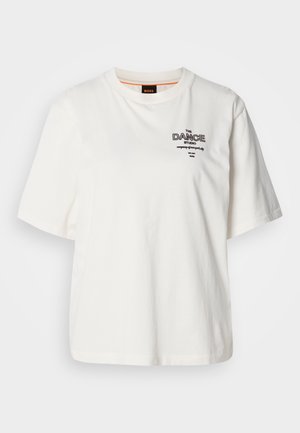 Valkoinen puuvillainen t-paita, jossa on pyöreä pääntie, lyhyet hihat ja mustalla kirjailtu teksti "THE DANCE STUDIO" edessä.