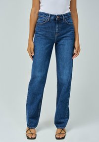 Jeans de denim azul de talle alto con un corte recto, que presentan costuras naranjas y un cierre frontal de botón. Textura suave y diseño clásico.