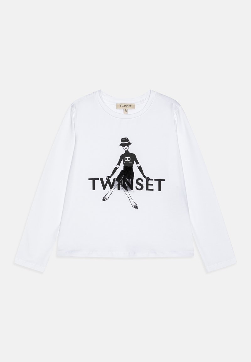 White long-sleeve shirt featuring a black graphic design of a figure in a dress, with "TWINSET" text below. Cotton material, relaxed fit.