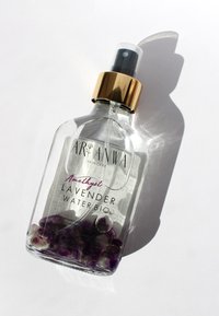 Bouteille vaporisateur en verre transparent avec un capuchon doré, contenant de l'eau de lavande et des cristaux d'améthyste. L'étiquette arbore un élégant texte noir et violet.