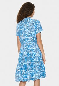 Gestreiftes Kleid in Blau und Weiß mit kurzen Ärmeln, einem weit ausgestellten Rock und einem gerafften Taillenbereich für einen entspannten Sitz. Glattes, leichtes Material.
