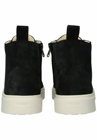 Černé semišové kotníkové boty s krémovou fleecovou podšívkou, vybavené bočními zipy a bílou gumovou podrážkou. Zadní poutko pro snadné obouvání.