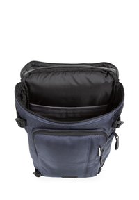 Mörkblå ryggsäck med texturerad yta, flera fack, dubbla dragkedjor och justerbara remmar. Inuti finns en vadderad foder.