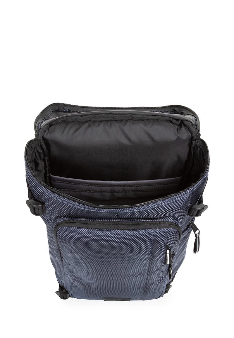 Sac à dos bleu marine avec une surface texturée, plusieurs compartiments, double zip et bretelles ajustables. L'intérieur est équipé d'un rembourrage.