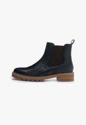 Stivale Chelsea in pelle nera con dettagli brogue, pannelli elastici laterali, asola posteriore e suola in gomma marrone spessa con tacco basso.